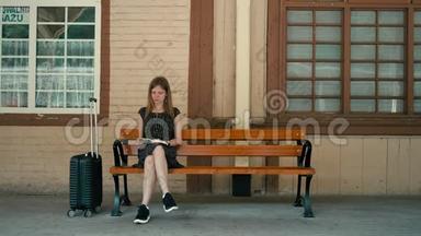 白种人年轻女士正在车站站台等火车，正在看书